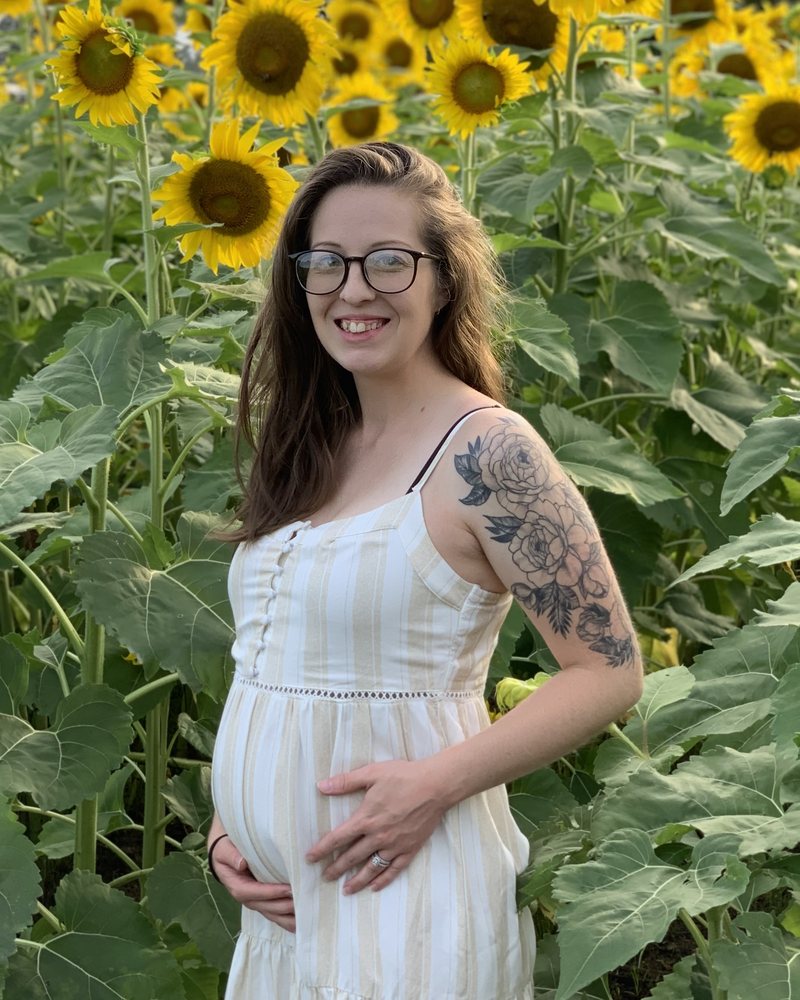 Miranda, the early childhood teacher behind KQ Learning Studio, standing in a sunflower field.